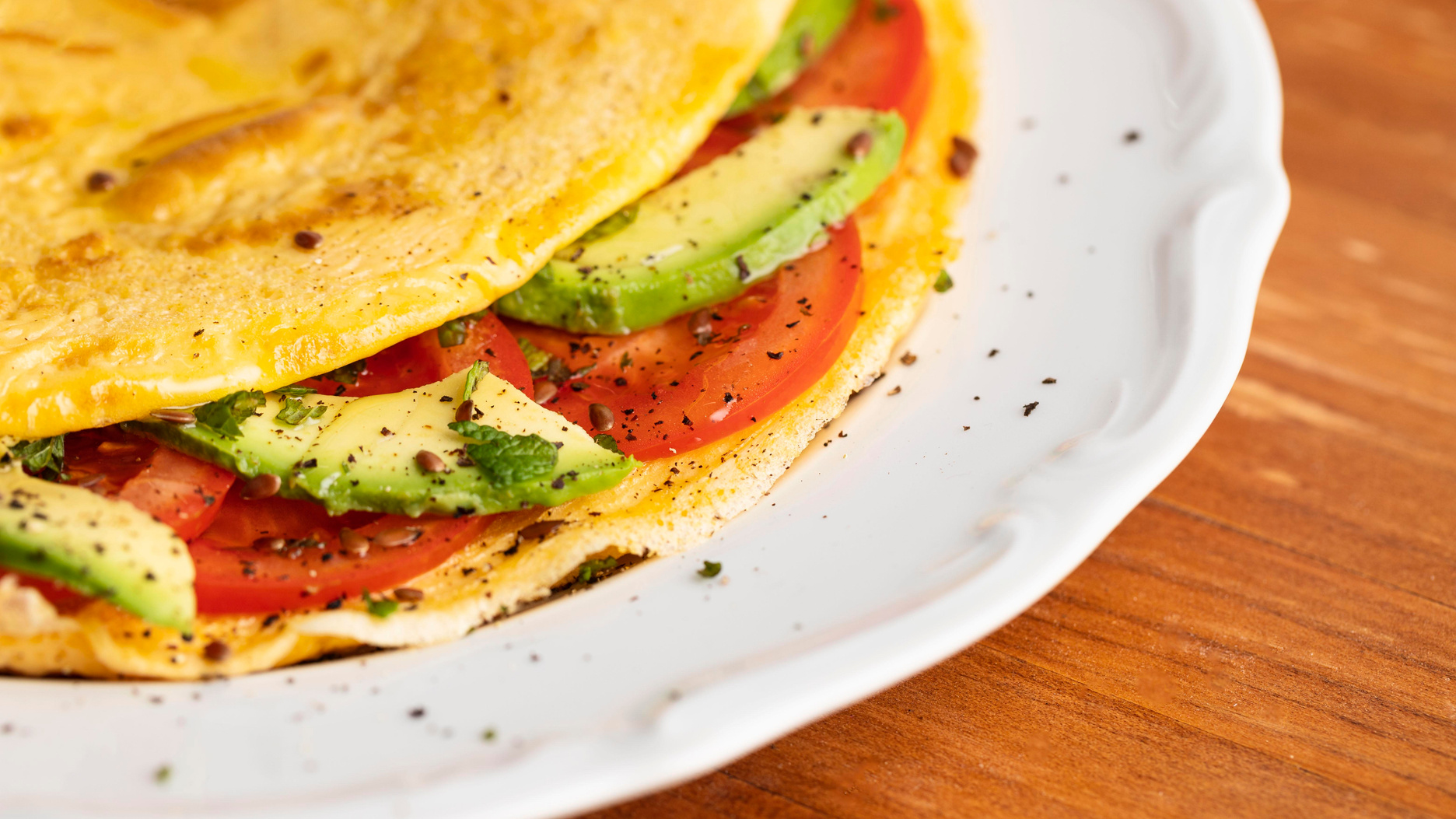 close up omelet with tomatoes avocado plate